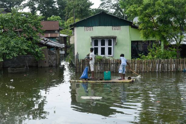 Flood in Assam People in a flooded area, due to monsoon rains, in a flood affected village in Morigaon district of Assam on 13 July 2020. brahmaputra river stock pictures, royalty-free photos & images