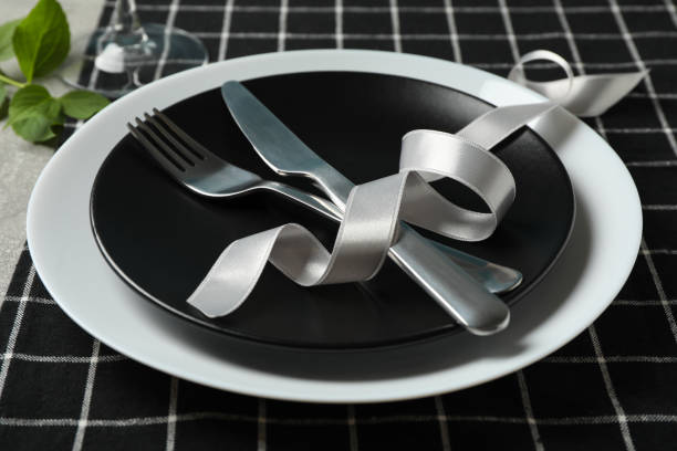 istock Table setting with black napkin, cutlery and wine glass, close up 1256995691