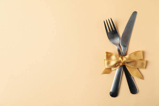 istock Cutlery with bow on beige background, space for text 1256996380