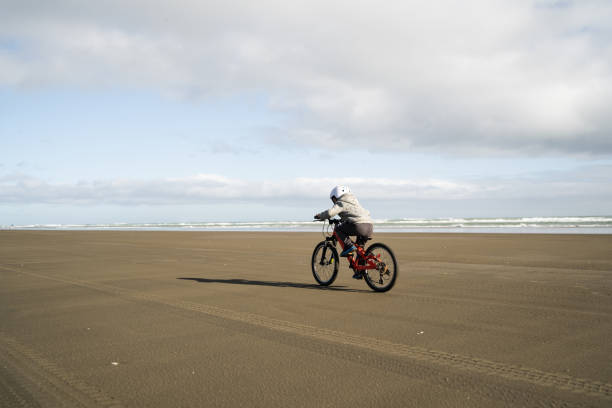 istock Kid bicycling on beach. 1256997260