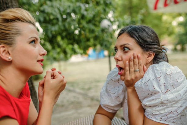 istock Friends sharing a secret while sitting in a cafe 1256999439