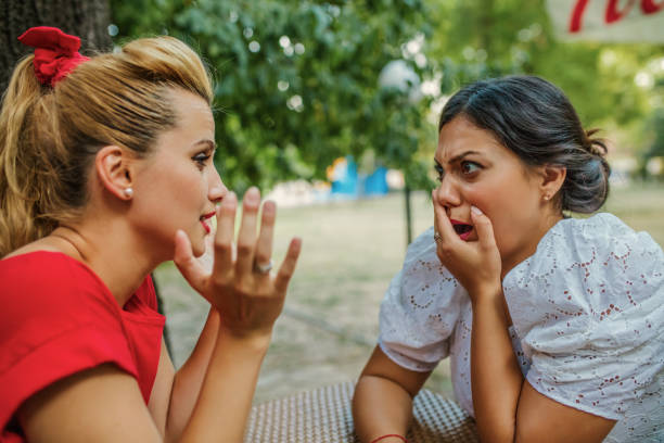 istock Friends sharing a secret while sitting in a cafe 1256999444