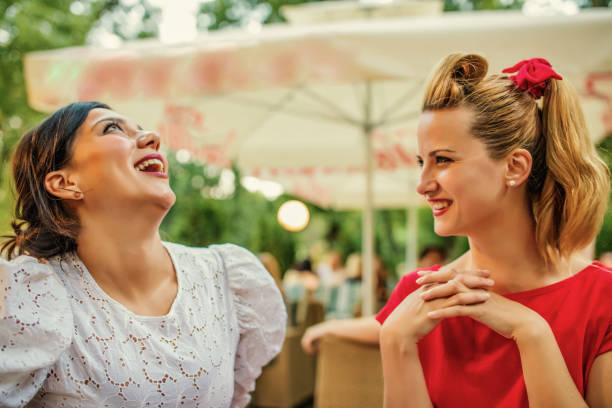istock Friends sharing a secret while sitting in a cafe 1256999567