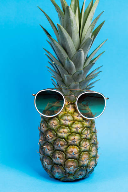 istock Ripe pineapple blue background with glasses 1257000732