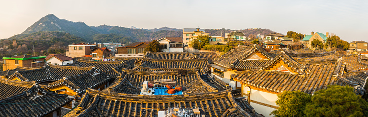 Mountain ridges overlooking the traditional wooden homes of Bukchon Hanok village in the heart of Seoul, South Korea’s vibrant capital city.