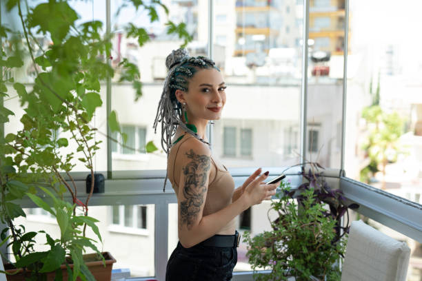istock Young woman using phone in balcony 1257003062