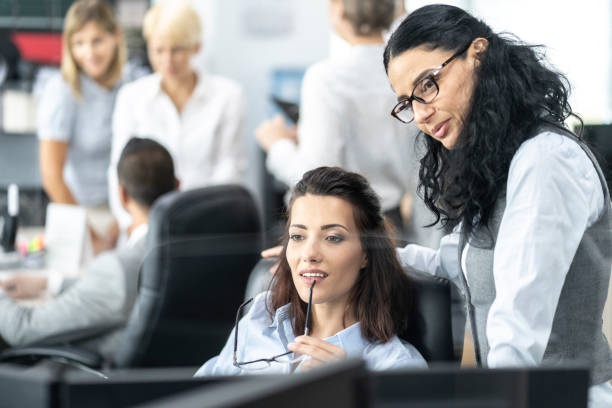 istock Female businesswomen looking at PC discussing financial projects 1257003171