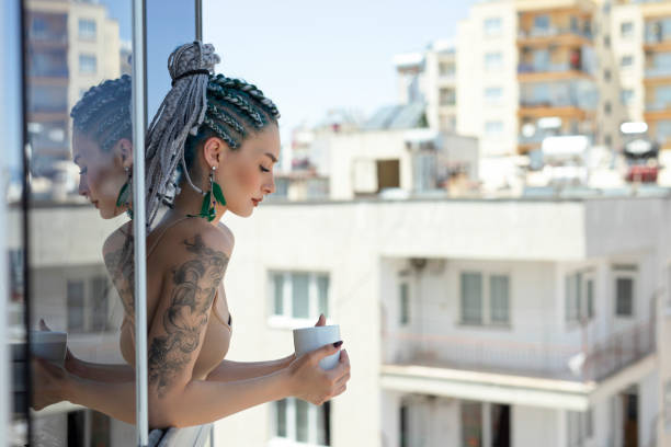 istock Young woman enjoying in balcony 1257003934