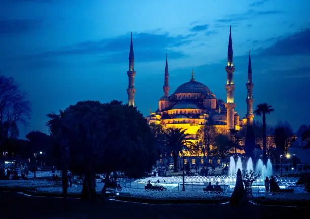 Blue mosque in Istanbul - famous landmark of islam architecture in Turkey. Four minarets of ancient mosque at night lights, ottoman architecture style.