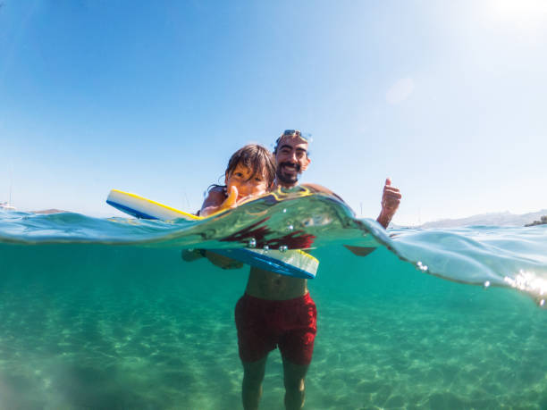 istock Father and son having fun in the sea 1257007782