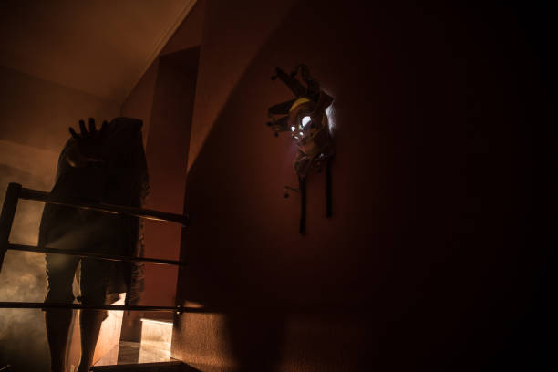 istock Horror concept. Scary mask with light on the wall inside dark room. Selective focus 1257008610