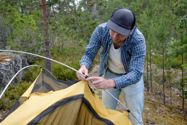 istock Male tourist making a tent at forest camp. 1257009855