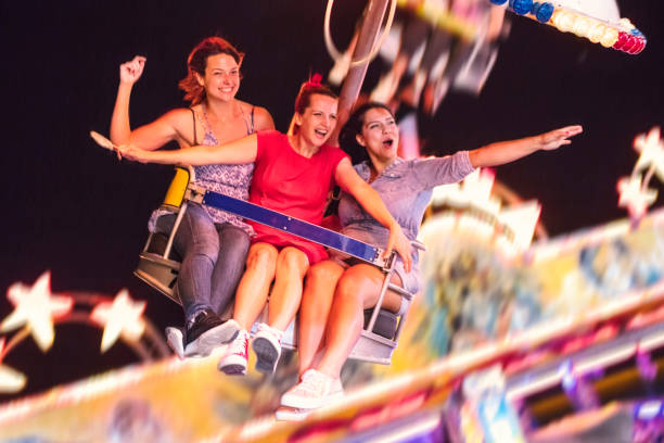 istock Girls on swing ride at night 1257012072