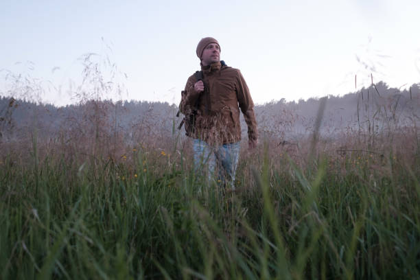 istock Man walking in a misty meadow hiking in the evening. 1257012125