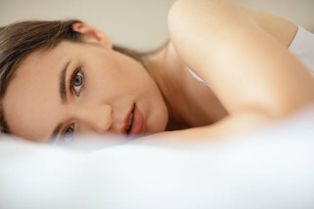 istock Beautiful young woman lying on bed 1257012532