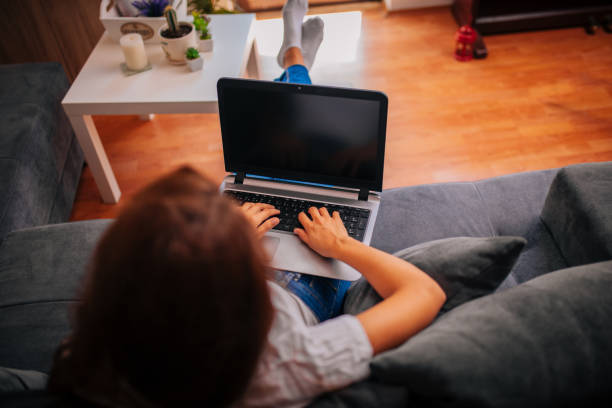 istock Pensive woman with protective face mask reading an e-mail on laptop at home. 1257012657