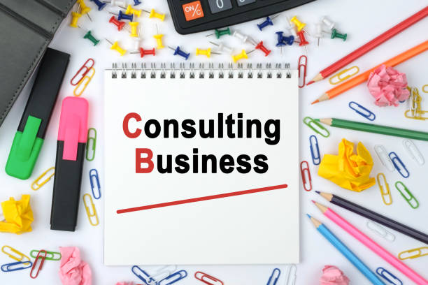 istock On the table is a calculator, diary, markers, pencils and a notebook with the inscription - Consulting Business 1257014615