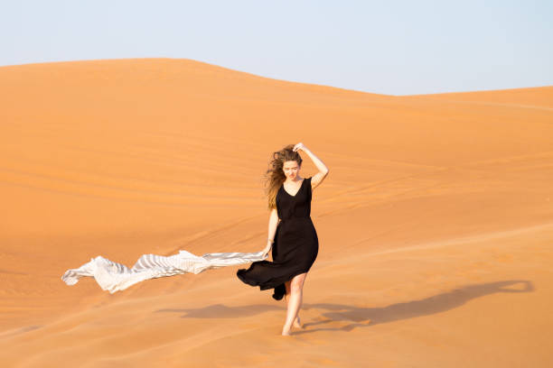 istock A lonely girl goes down the sand dunes. 1257015933