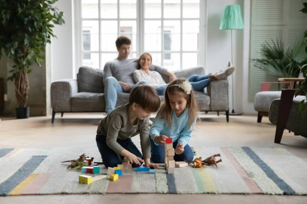 istock Little kids play with building blocks at home 1257016156