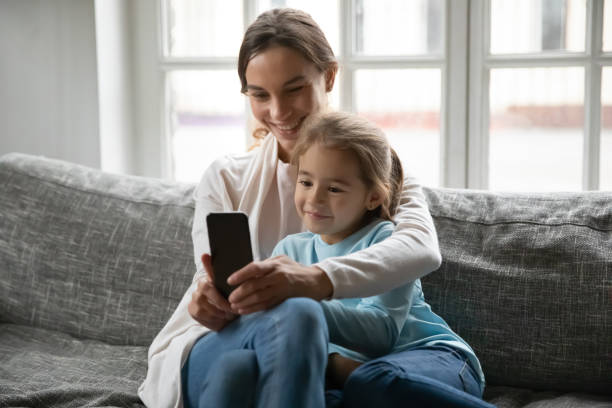 istock Young mother and small daughter take selfie on cellphone together 1257016178
