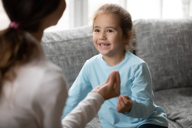 istock Little girl make hand gesture learn sign language with mom 1257016196
