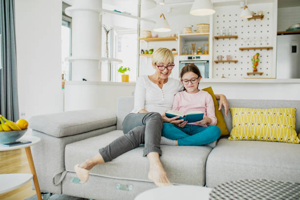 istock A grandmother and granddaughter reading on sofa 1257018816