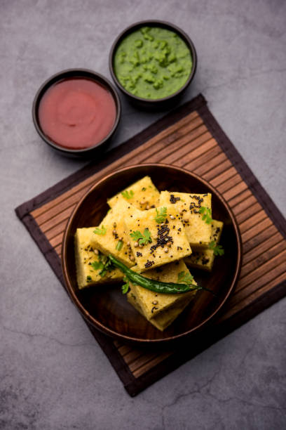 gujarati khaman dhokla ou gâteau à la vapeur gram flour puffy snack - puffed photos et images de collection