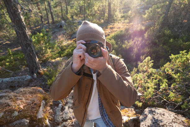 istock Male tourist using digital camera outdoors in a forest 1257021076