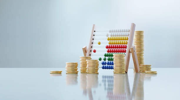 Abacus and coin stacks sitting in front of defocused background. Horizontal composition with copy space. Great use for home finances and budget concepts.