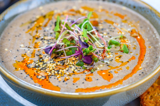 A serving of mushroom soup in a round blue textured bowl