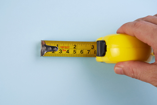 human hand with tape-measure isolated on blue