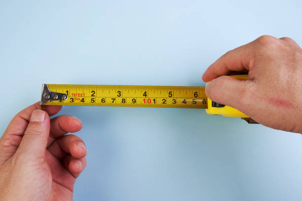 istock Diy concept.Hand holding tape measure on blue background 1257024309