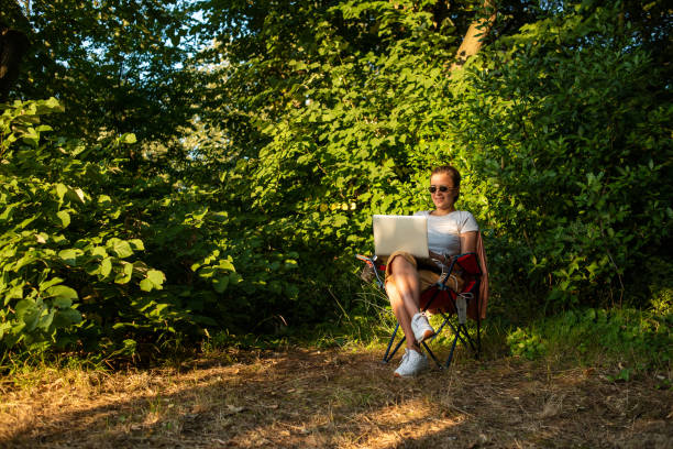 istock Young woman working with laptop in nature 1257025337