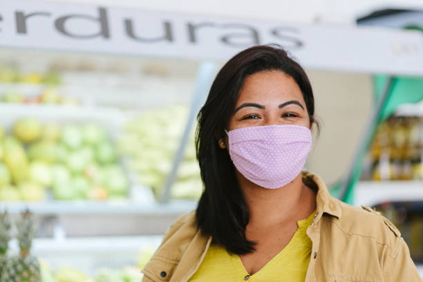 covid19: lächelnde frau im gemüsebereich des supermarktes - 2650 stock-fotos und bilder