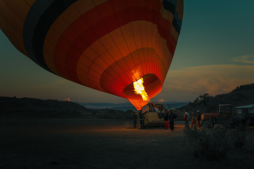 Hot air balloon with bright burning flame in the night
