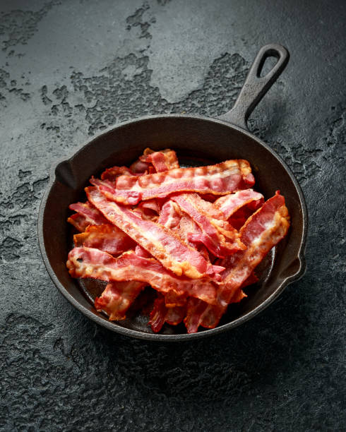 istock Fried crunchy Streaky Bacon pieces in a cast iron skillet 1257031914