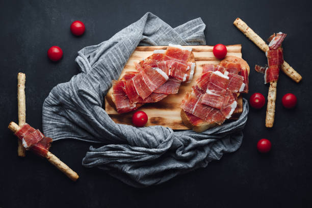 Ham still life cut with bread, oil and tomato stock photo