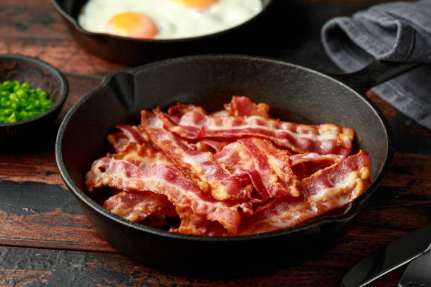 istock Fried crunchy Streaky Bacon pieces in a cast iron skillet 1257032848