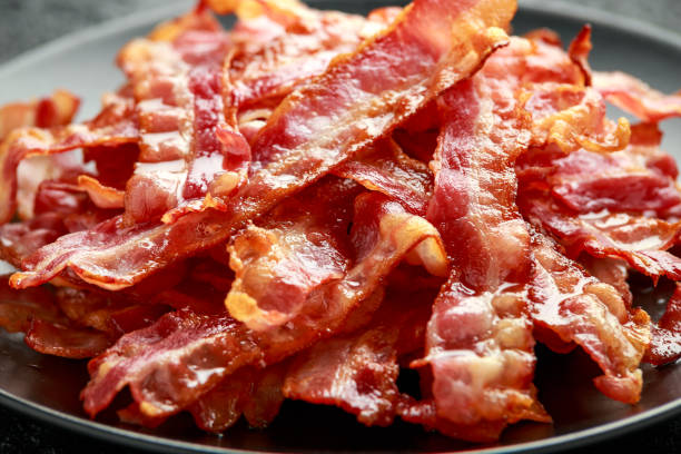 istock Fried crunchy Streaky Bacon pieces in a black plate 1257032885