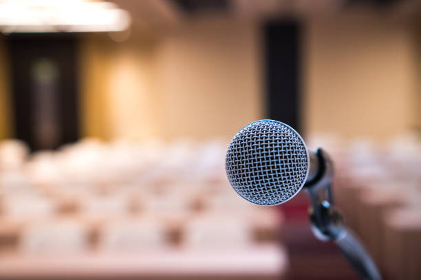 istock Microphone for speaker of speech or speaking at seminar conference room, talking for lecture to audience university, Event light convention hall in Business Talk speaking in training 1257033174