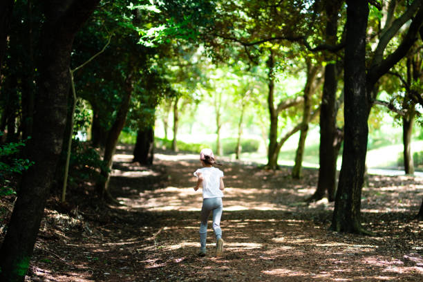 istock Girl running in nature park 1257033303