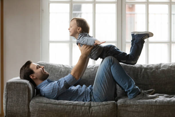 istock Happy father and little son playing funny game on couch 1257033404