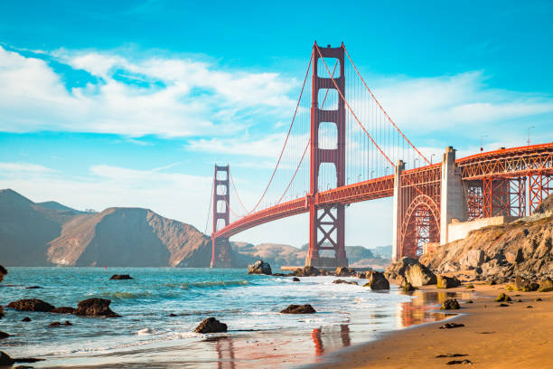 Golden Gate Bridge at sunset, San Francisco, California, USA Classic view of famous Golden Gate Bridge in beautiful golden evening light on a sunny day with blue sky and clouds in summer, San Francisco, California, USA baker beach stock pictures, royalty-free photos & images
