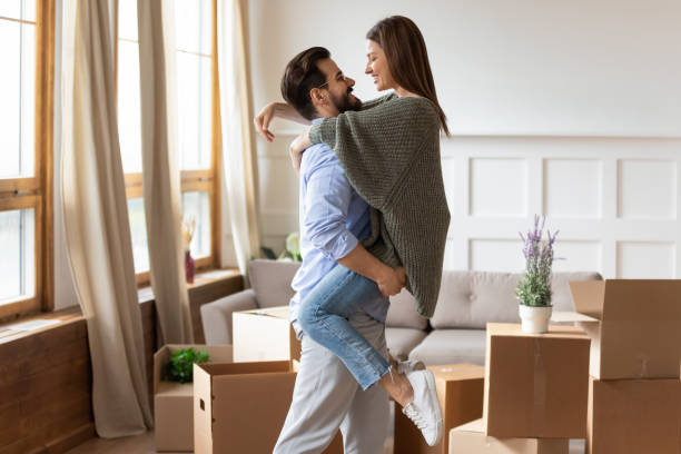 istock Strong affectionate young man in glasses lifting smiling wife. 1257040813