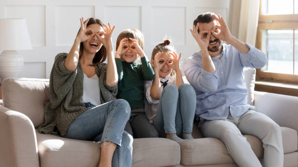 istock Overjoyed full family making binoculars with fingers. 1257040928