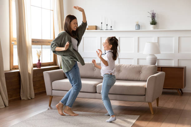 muito feliz jovem mamãe babá dançando música com menina. - vip room - fotografias e filmes do acervo