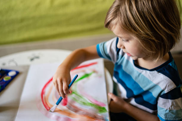 istock Little child is painting rainbow 1257043674