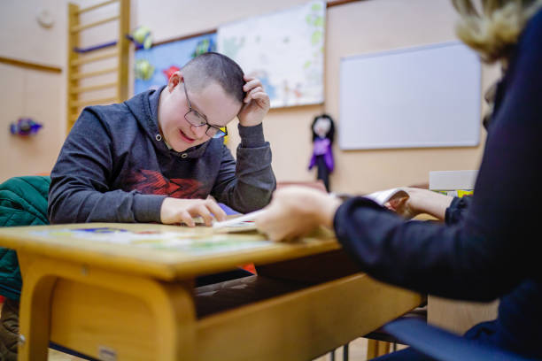 istock Special needs teen boy working with female speech therapist 1257046530