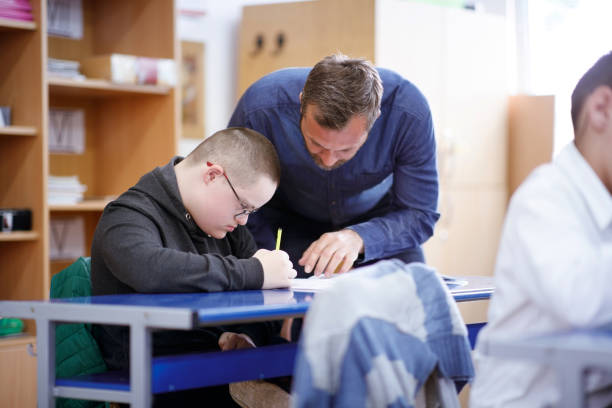 istock Teacher helping intellectual disabled boy on his drawing skills 1257046591