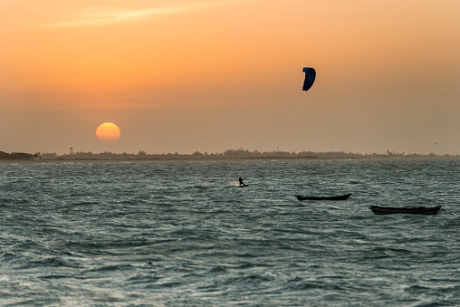 Kitesurfing at Barra Grande beach coastline, with the sunset on the background.
